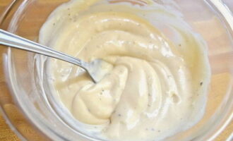 Læg mayonnaise i en separat skål. Vi befrier hvidløgsfeddene fra skallerne og passerer dem gennem en presse til mayonnaisen. Smag ingredienserne til med sort peber og salt. Bland og tilsæt til krabbestænger, ost og æg. Bland massen.