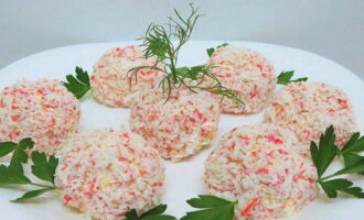 Ilipat ang natitirang tinadtad na crab sticks sa flat bottom plate. Igulong ang mga bola sa kanila. Ilagay ang mga ito sa isang malaking ulam. Hugasan ang mga gulay at iwaksi ang labis na likido. Palamutihan ang alimango na may Raffaello at ihain kasama ng beer.