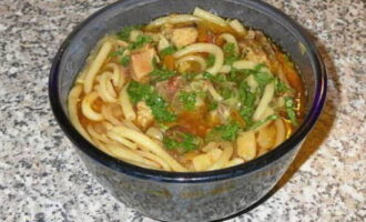 Add noodles to the lagman and sprinkle the dish with chopped herbs, stir and serve.