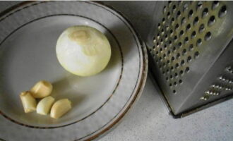 Peel one onion and several cloves of garlic and chop using a fine grater.