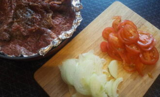 Cut the peeled onions into thin half rings, tomatoes into circles.