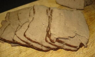 Cut the boiled liver into thin slices and then into strips.