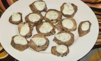 Place the tongue slices on a flat dish and pour over the aromatic garlic and sour cream sauce. 