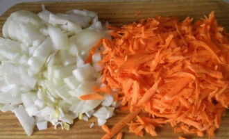 Meanwhile, grate the peeled carrots and cut the remaining onions into cubes.