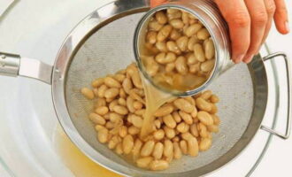 How to prepare a simple and tasty salad with kirieshki? Uncork the jar of beans and place the beans in a colander. We rinse and leave the beans in a colander for a while to drain the liquid.