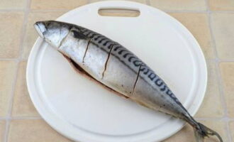 How to cook the most delicious mackerel in the oven? We gut the fish and remove the gills, rinse thoroughly under running water and make three deep cuts on both sides, sprinkle with salt and pepper.