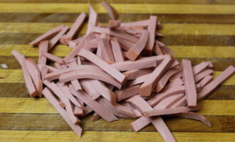 Remove the sausage from the casing and cut into strips. 