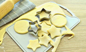 Togliere l'impasto dalla pellicola o dal sacchetto. Stendere uno strato di piccolo spessore da esso. Quindi utilizziamo eventuali formine per biscotti.