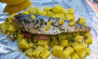 At this time, take a sheet of foil and grease it with vegetable oil. Depending on the number of servings, lay out some of the potatoes, and put pickled mackerel on top. Sprinkle everything with finely chopped dill and add lemon slices if desired. 