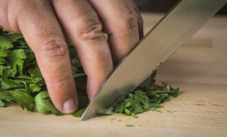 Basuh sayur-sayuran pilihan anda - dill atau pasli - dengan air mengalir dan goncangkan tandan itu.Kemudian potong sayur-sayuran dengan pisau. 