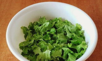 We tear clean leaf lettuce into small segments with our hands and put it in a salad bowl.