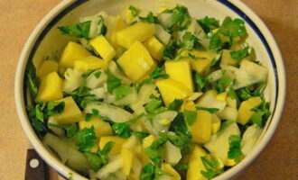 Peel and wash potatoes and onions. Cut them into cubes and place them in a deep plate. We also put chopped parsley here. Salt, pepper, sprinkle with suneli hops and stir the ingredients.