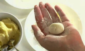 Bentuk bebola kecil dari jisim ini dengan tangan anda dan gulungkannya di semua sisi dalam tepung atau serbuk roti.