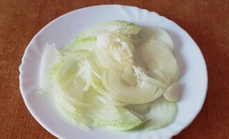 Peel the onion and cut it into thin half rings.