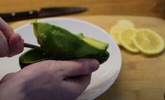 Using a spoon, scoop out the pulp from the avocado halves.