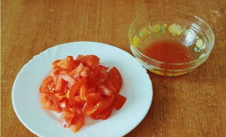 Potong tomato menjadi kepingan dan picit sedikit (tuangkan jus yang dilepaskan ke dalam mangkuk).