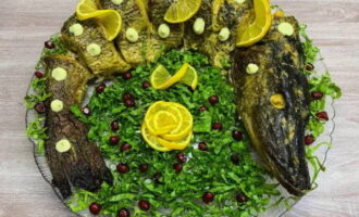 Decorate the carcass with lemon slices, chopped lettuce, drops of mayonnaise and pomegranate seeds. Bon appetit!