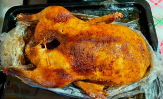 Then, after this time, cut the top of the bag and unfold it a little. Pour the carcass generously with melted fat and continue baking for another 25 minutes, turning on the convection, so that the bird is covered with a golden brown crust.