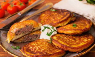 We transfer the golden potato pancakes with meat to plates, pour sour cream on them and enjoy. Bon appetit!