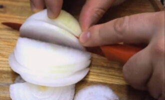 Peel the onions and cut them into half rings.