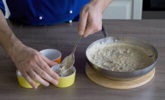 Vi breder ut juliennen i cocotte makers. Riv osten. Strö rätten med det. Placera cocotte makers på en bakplåt, som vi placerar i den förvärmda ugnen. Vid en temperatur på 200 grader, grädda juliennen i 5 minuter.