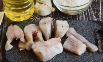 Pollock marinated with onions and carrots is very easy to prepare. We clean the pre-defrosted carcass and rinse thoroughly under running water. Cut into portions of the desired size and rub with salt on all sides (adjust the amount at your discretion).