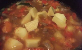 After an hour, add large cubes of potatoes, sweet peppers and tomatoes to the broth. Season with laurel and boil until the potatoes are ready.