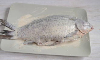 Carefully rub the fish with sour cream so that the salt and spices get into all the cuts.