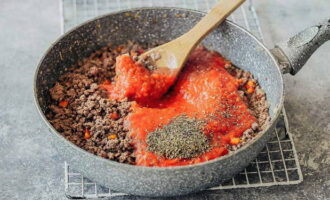 Grind the peeled tomatoes with a blender at maximum speed and pour this mass into a frying pan with the minced meat. Then sprinkle the dish with salt, pepper and spices (basil and oregano), mix and simmer the Bolognese over low heat for 20 minutes.