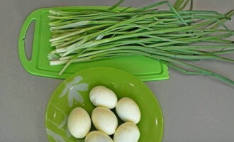 During this time, the filling for the pie is prepared. Green onions are washed, dried with a napkin and chopped into small pieces. Hard-boiled eggs are peeled and cut into cubes.