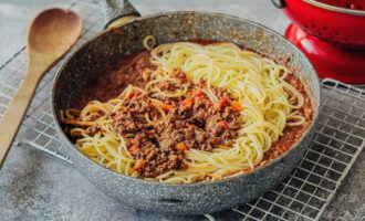 Place the cooked spaghetti in a frying pan on top of the Bolognese sauce, heat the dish under the lid, sprinkle with shredded cheese and complete the cooking process with a beautiful presentation. Bon appetit!