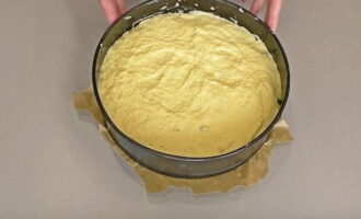 The rest of the dough is laid out on top of the filling, and its surface is leveled with a spoon.