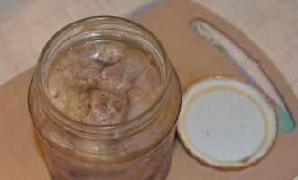 Carefully remove the glass containers with the stew from the hot water, screw them in or roll them up using a special machine and leave them on the work surface until they cool completely (for a day).