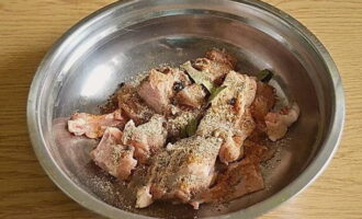 Transfer the chicken to a deep container, add salt, dry garlic, allspice, ground black pepper, peppercorns, bay leaf and chicken seasonings. Peel the onions, chop them into small pieces and send them to the meat. Mix everything thoroughly. 