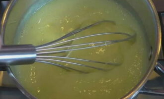 Now put the saucepan on low heat and cook the milk mixture, stirring continuously with a whisk. Mix especially thoroughly at the bottom so that no lumps of flour form there. After the cream thickens, remove it from the stove.