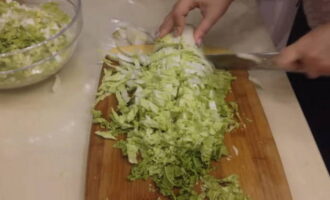 Salad with Chinese cabbage and corn is quick and easy to prepare. A head of Chinese cabbage is rinsed with cold water and chopped into small pieces of arbitrary shape. The cabbage slices are immediately placed in the salad bowl.