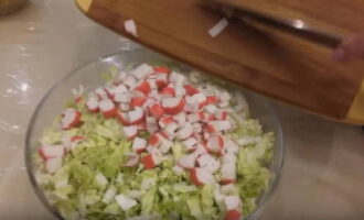 High-quality crab sticks, defrosted in advance, are removed from packaging and cut into thin cubes.