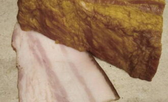 The bacon is cut with a sharp knife into the thinnest oblong slices possible.