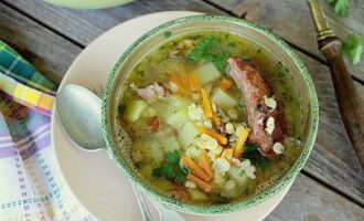 Bereide erwtensoep met gerookte ribben wordt in kommen gegoten en geserveerd voor de lunch.Eet smakelijk!