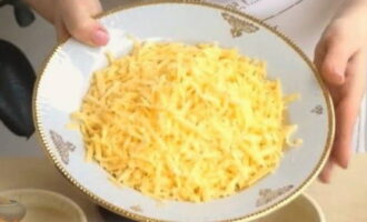 How to cook potatoes in pots with meat and mushrooms in the oven? A piece of hard cheese is crushed on a coarse grater.