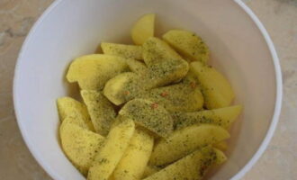 Place the potato slices in a deep container and add salt and sprinkle with any spices to your taste.