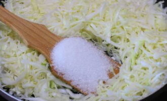 Then add a spoonful of sugar to the cabbage, mix everything well, and transfer the cabbage to the salad bowl.