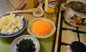 Cut the potatoes into small cubes. Grind the carrots on a medium or coarse grater. Wash the dill and chop finely.