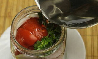 Place the rest of the greens on top of the tomatoes. Pour boiling water over the vegetables in the jar, cover with a lid and leave for 15 minutes.