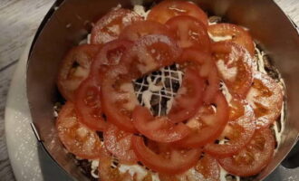 La cinquième couche est disposée dans un cercle de tomates concassées, saupoudrez-les de sel et de poivre moulu au goût.