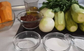 Prepare all vegetables and spices according to the recipe. Peel and rinse vegetables. It is better to choose young zucchini, cut into large cubes. Grind the carrots using a Korean grater. Cut the onion into thin quarter rings. Finely chop a bunch of greens with a knife.