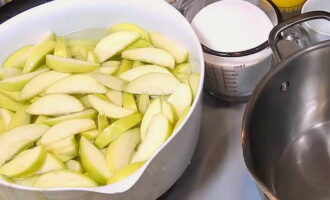 Apfelmarmelade für den Winter zuzubereiten ist ganz einfach. Waschen Sie die zum Kochen ausgewählten Äpfel gründlich und entfernen Sie die Kernkapseln. Für die Marmeladenzubereitung 3 Liter kaltes Wasser in eine Schüssel geben und 1/3 Teelöffel Zitronensäure darin auflösen. Die Äpfel in gleich dünne Scheiben schneiden und in eine Schüssel mit Wasser geben. Zitronensäure verhindert, dass Äpfel dunkel werden.