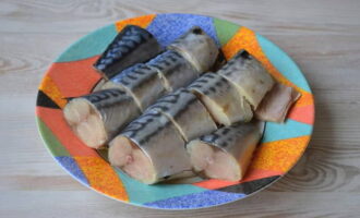 Preparare lo sgombro in barattolo per l'inverno è molto semplice. Per questa preparazione non scongeliamo completamente il pesce in modo che i pezzi mantengano la loro forma durante il taglio. Poi puliamo lo sgombro, lo sciacquiamo sotto l'acqua corrente e lo tagliamo a pezzi. Cospargeteli di sale e versate il succo di mezzo limone.