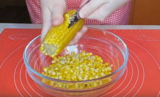 How to prepare a delicious corn preparation for the winter? Boil the corn cobs selected for canning in water without adding salt for 30-40 minutes, which depends on the degree of maturity of the grains. Then cool the corn under running water in a colander. Using a knife, carefully separate the kernels from the cobs.