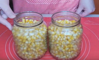 Rinse the jars for the preparation well with soda and sterilize them together with the lids using any method. Place corn kernels in prepared jars. 